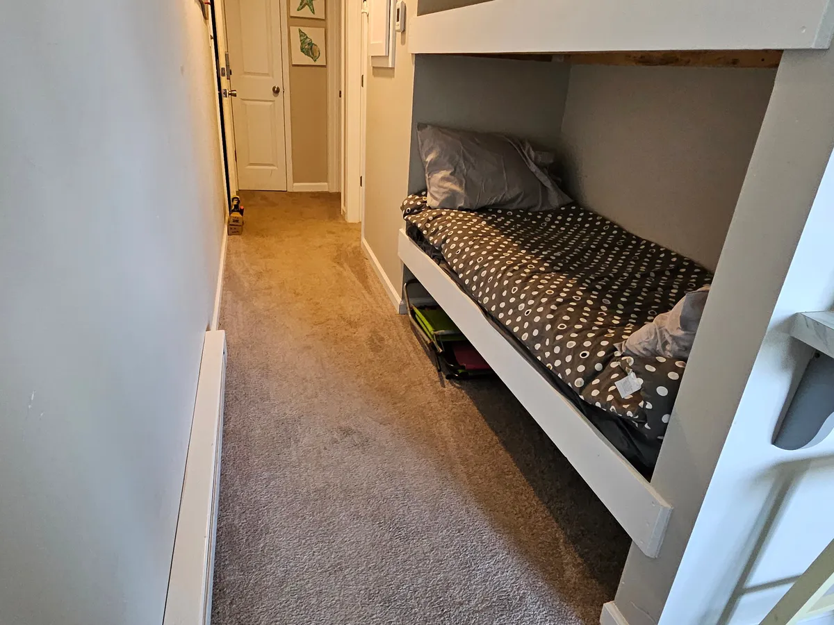 A cozy hallway with a bunk bed and decorative accents on the wall, creating a family-friendly and inviting ambiance. The space is practical, well-lit, and designed for relaxation and intimate conversations.